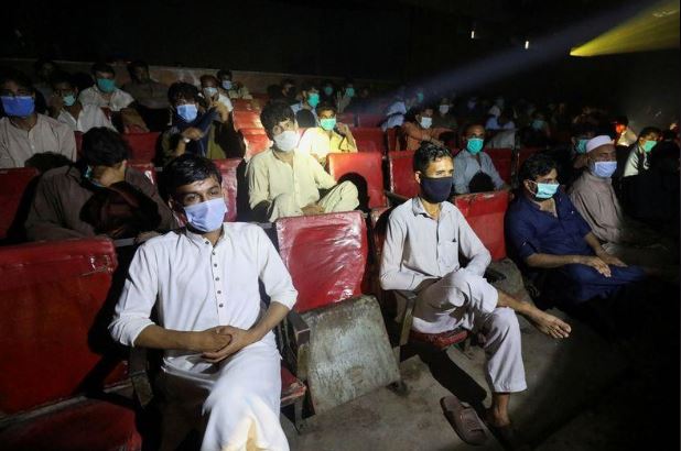 أشخاص يضعون كمامات للوقاية من فيروس كورونا في دار للسينما في بيشاور بباكستان. تصوير: فايز عزيز - رويترز.